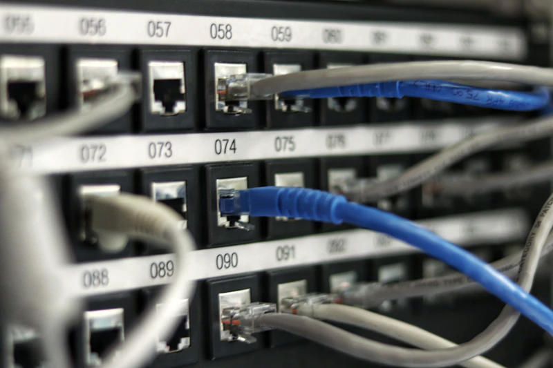 Sala de operações com racks de rede e cabeamento organizado